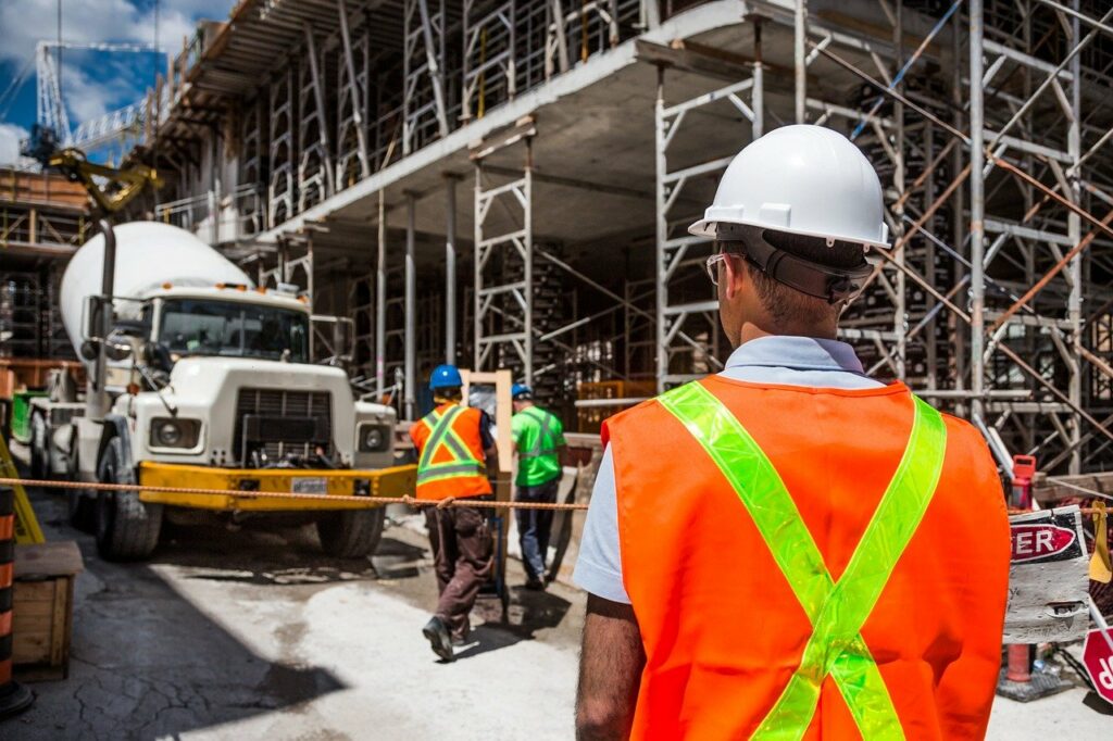 A man in a hard hat looking at a truck.